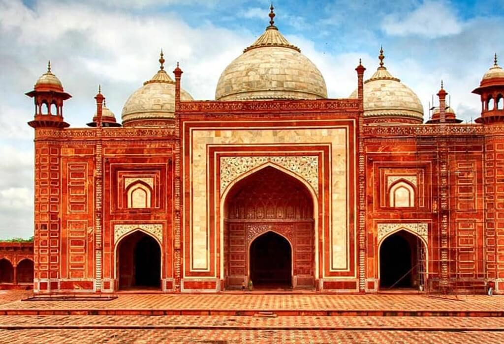 "Panoramic view of Humayun's Tomb in Delhi, showcasing its stunning red sandstone and white marble architecture under a partly cloudy sky."