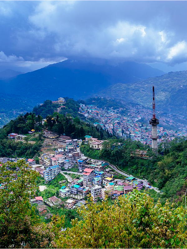 "Stunning view of the Himalayas from Darjeeling, serene landscapes and monasteries of Pelling, and colorful buildings of Gangtok nestled in the hills."